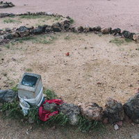 石に囲まれた砂地と石碑（世界エネルギーセンター）の写真