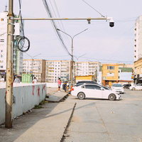 古びた壁と監視カメラが映す都市の日常の街角風景の写真