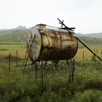 モンゴルの草原に放置されたさびたタンクの風景の写真