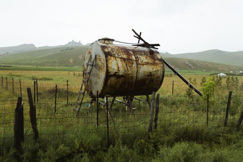 モンゴルの草原に放置されたさびたタンクの風景