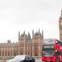 赤い2階建てバスとビッグベンが見えるロンドンの街角の写真