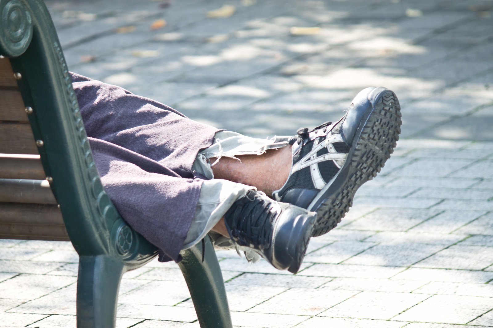 ベンチに横たわる人の足元