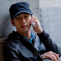 路上で不安そうに電話する男性の写真