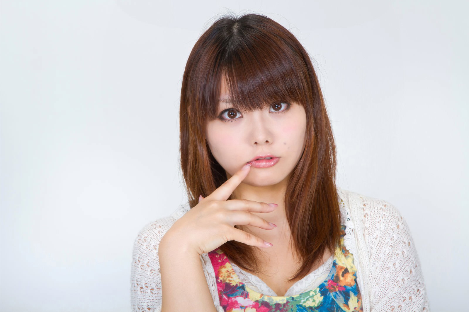 口元に指を当てて見つめる女性［モデル：Lala］