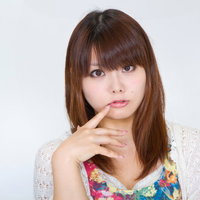 人差し指を口元に当ててこちらを見つめる女性の写真