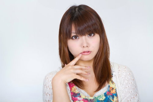 人差し指を口元に当ててこちらを見つめる女性