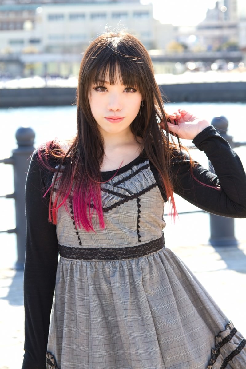 埠頭の海を背にポーズする女性