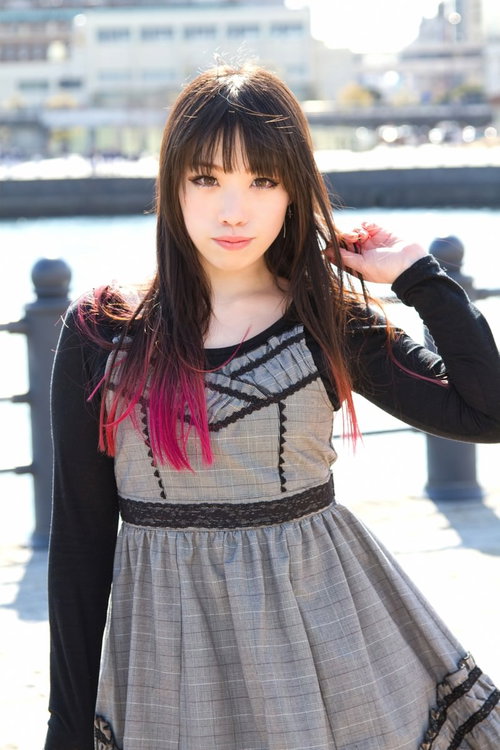 埠頭の海を背景にポーズをとる女性のポートレート