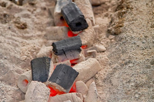 焚き火の後に残る灰色の灰と黒い木炭の残骸