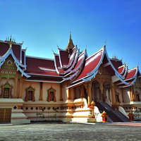 金色の仏塔が見えるラオス共和国タート・ルアンの入口の写真