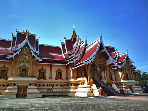 金色の仏塔が見えるラオス共和国タート・ルアンの入口