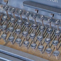 キーが並ぶ古い使い込まれたタイプライターの正面の写真