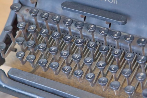 キーが並ぶ古い使い込まれたタイプライターの正面