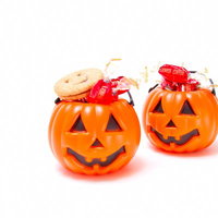 カラフルな飴がぎっしり入った二つの小さなハロウィンかぼちゃの写真