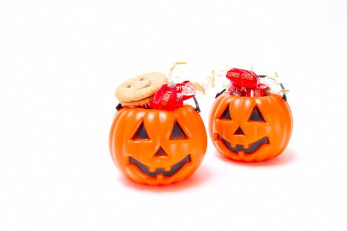 カラフルな飴がぎっしり入った二つの小さなハロウィンかぼちゃ