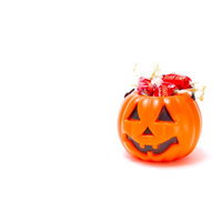 中にカラフルな飴が詰まったおばけ顔のハロウィンかぼちゃの写真