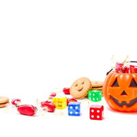 テーブルに散らばるお菓子と並ぶ複数のハロウィンかぼちゃの写真