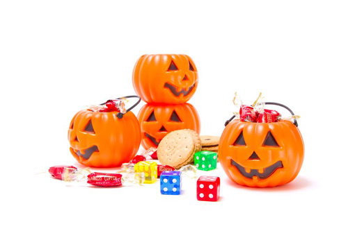 オレンジのかぼちゃランタンと色とりどりのハロウィン用お菓子