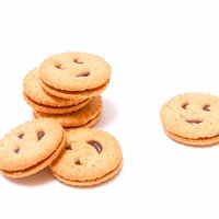 白い面の上に並ぶにっこり顔が描かれた丸いクッキーの写真