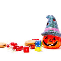 ろうそくの光が灯るかぼちゃのランタンとハロウィンのお菓子の写真