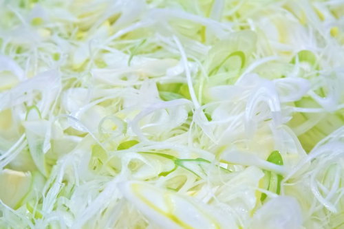 白い器に盛られた細く彫られた白髪ネギのクローズアップ