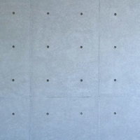表面の模様と穴が見えるコンクリート打ちっぱなしの壁の写真