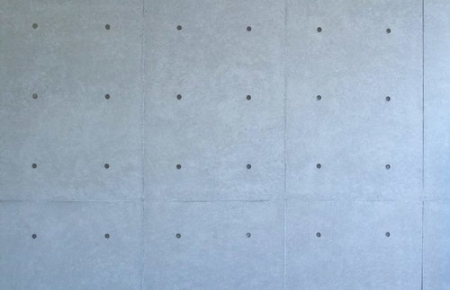 表面の模様と穴が見えるコンクリート打ちっぱなしの壁