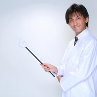 指示棒を持って前方を指す白衣の男性の案内ポーズの写真