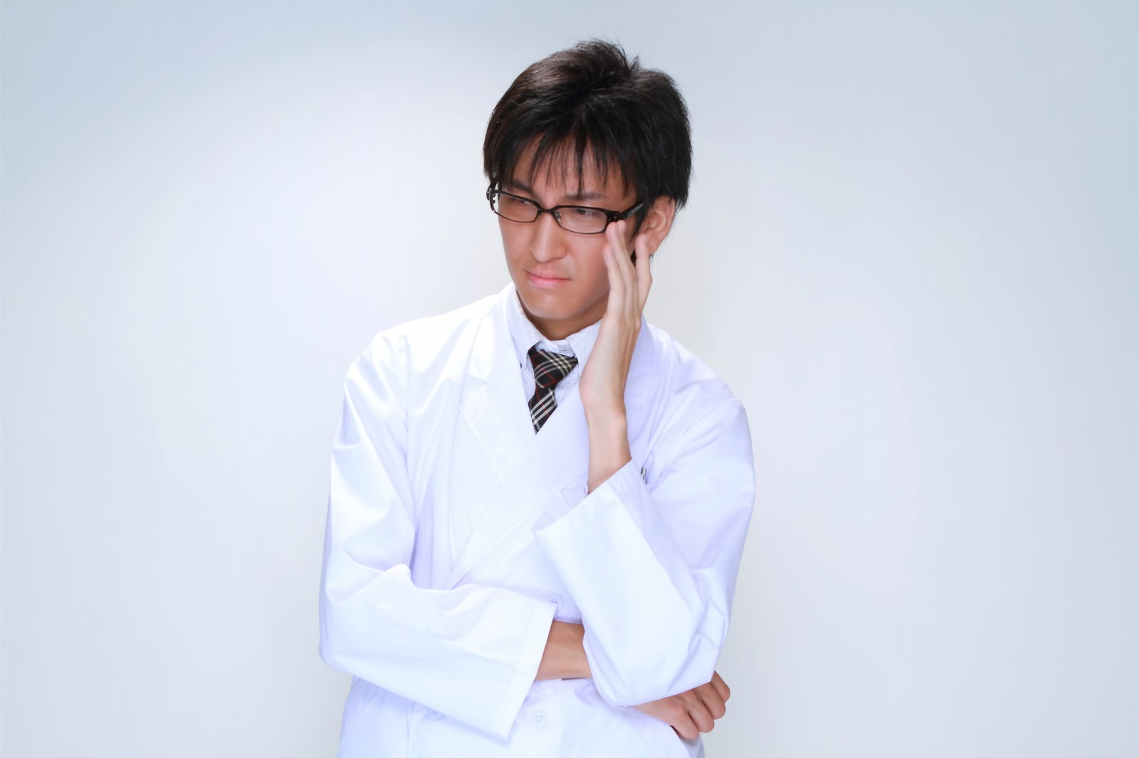 眼鏡を直す白衣の男性医師［モデル：ACE］