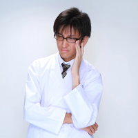 白衣を着て眼鏡のフレームを直す男性の医師の写真
