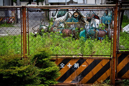 錆びた資材と瓦礫が散らばる荒れ果てた資材置き場