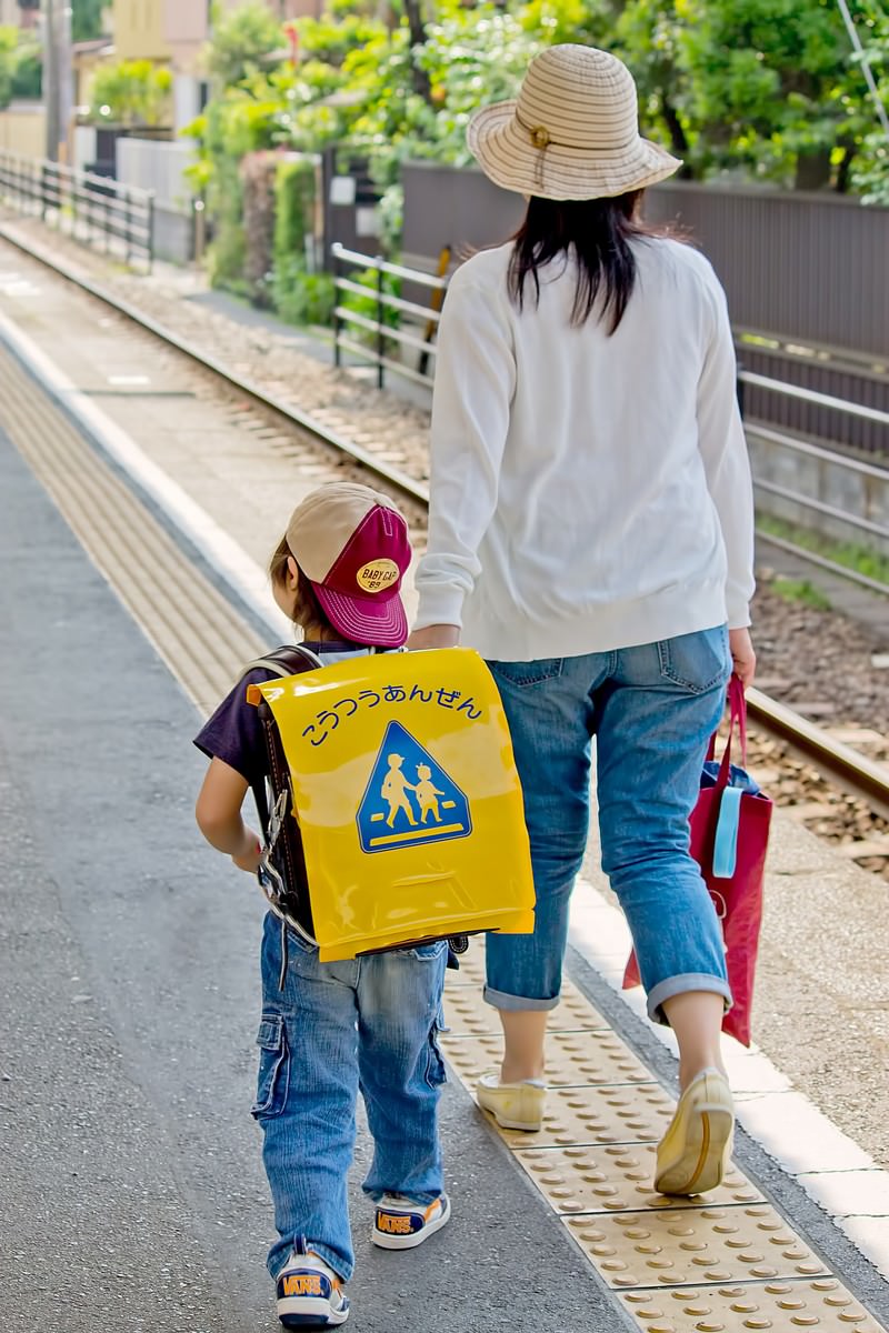 駅のホームを歩く親子の後ろ姿