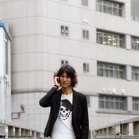 歩道橋の上でスマホで電話する男性の写真