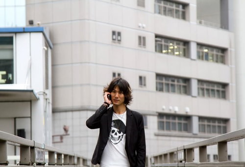 歩道橋の上でスマホで電話する男性