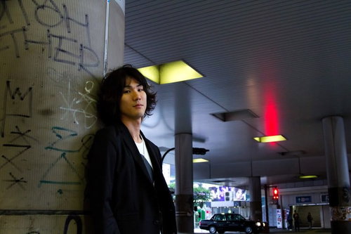 井の頭線下の歩道とこちらを向く男性