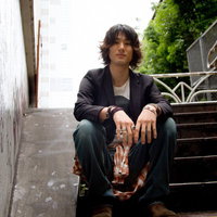 階段に座り街を見下ろす男性のポートレートの写真