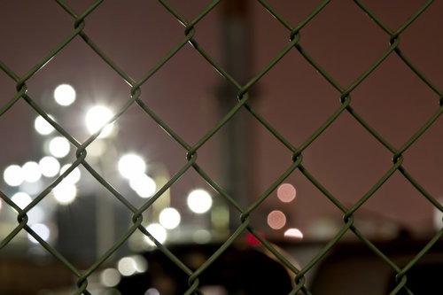 暗闇の中で金網越しにぼける丸い光