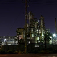 関係者立入禁止の看板と柵越しに光る工場の夜景の写真