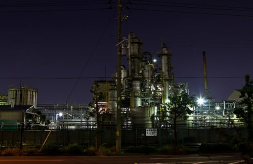 関係者立入禁止の看板と柵越しに光る工場の夜景