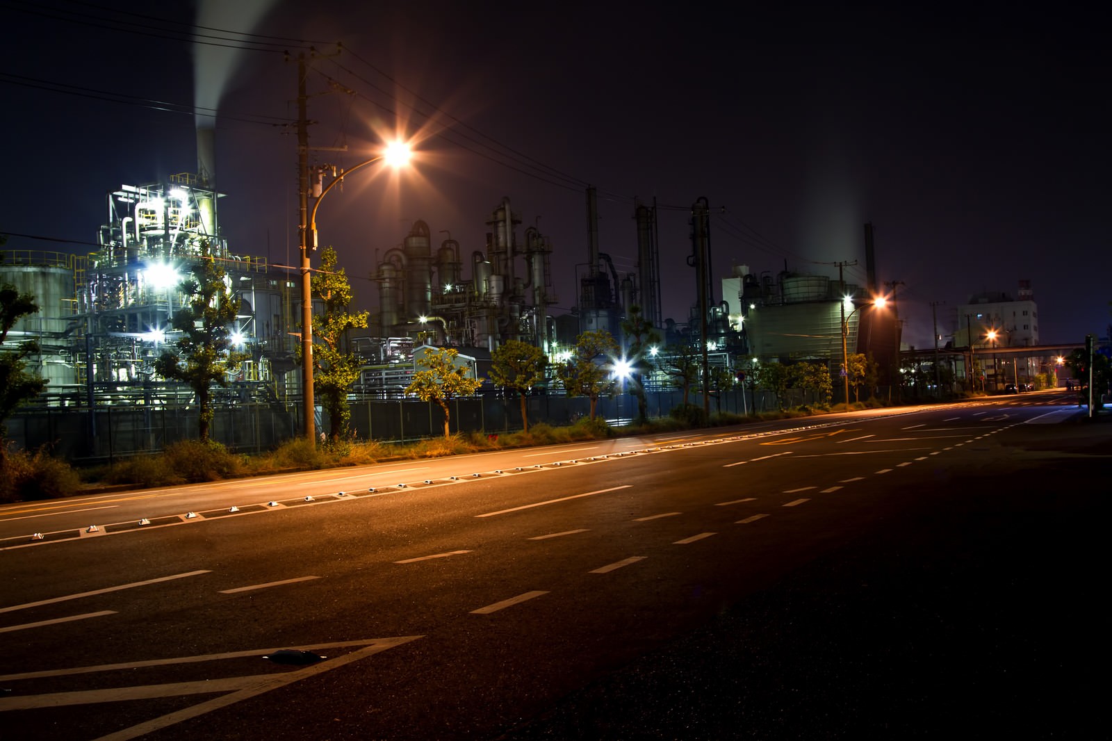 街灯が並ぶ道路と工場の夜景