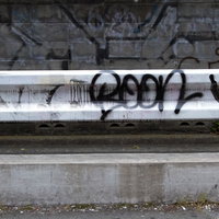 スプレーの落書きが描かれたコンクリートブロック塀の写真