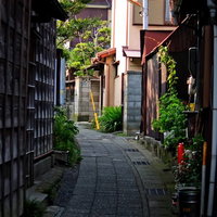 古い木造家屋が並ぶ石畳の路地裏の道の写真