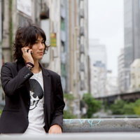 渋谷川の橋の上で電話する男性の写真
