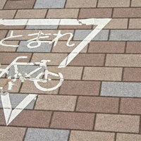 レンガ舗装に書かれたとまれの自転車マークの写真
