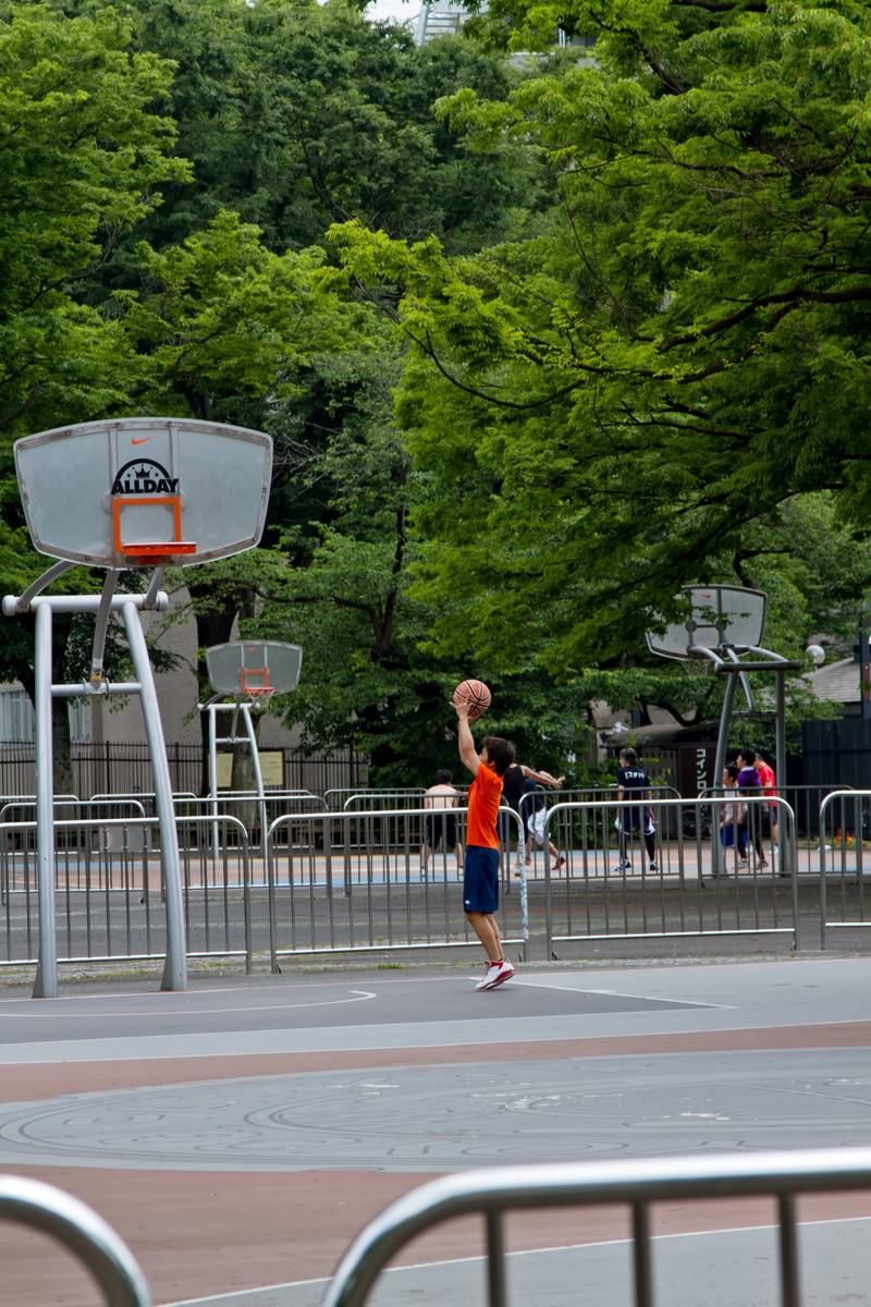バスケットコートで練習する少年