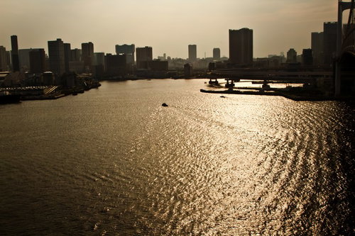 オレンジの夕焼けが水面に反射して光る海の風景