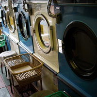 洗濯機と乾燥機が並ぶ古いコインランドリーの写真