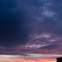 建物のシルエットと夕暮れのオレンジ空の写真