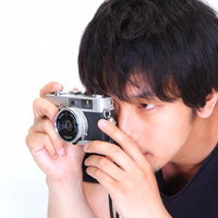 一眼レフを構えて「僕は撮り逃さない」と意気込む男性の写真