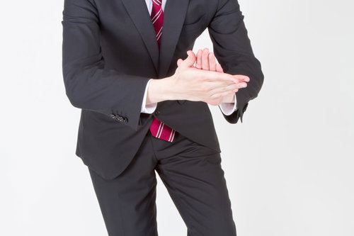 「イヨッ！社長」と手を叩いておべっかを使うスーツのサラリーマン